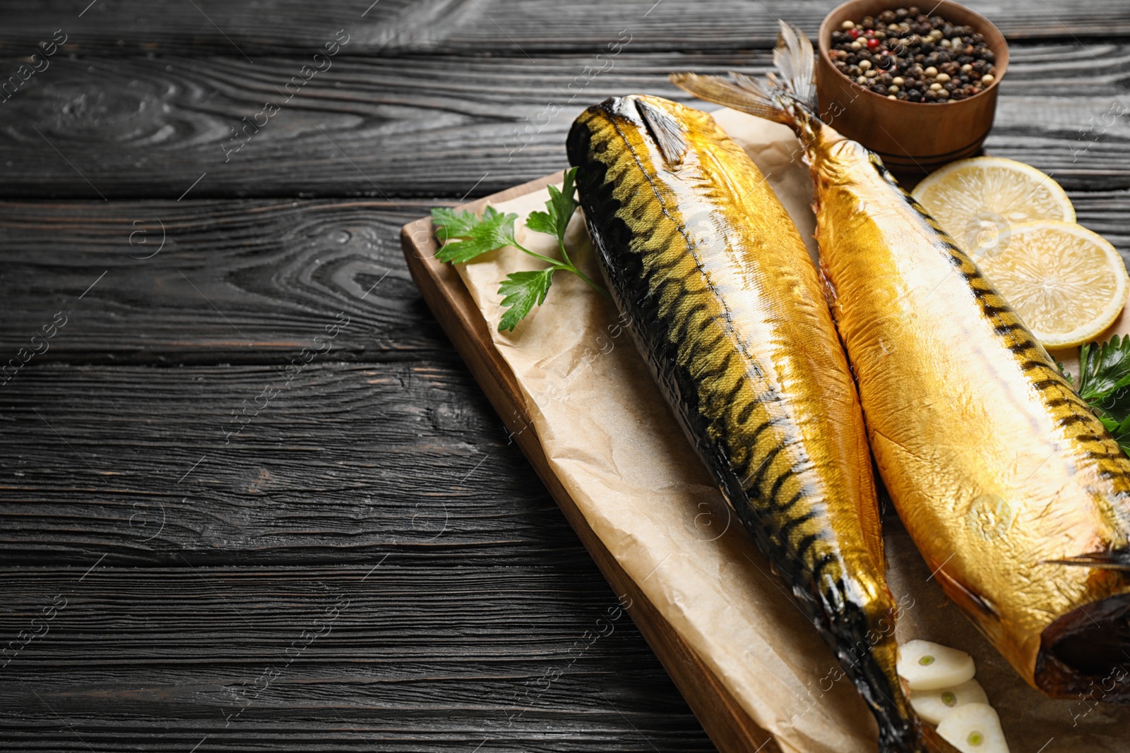 Photo of Tasty smoked fish served on wooden table