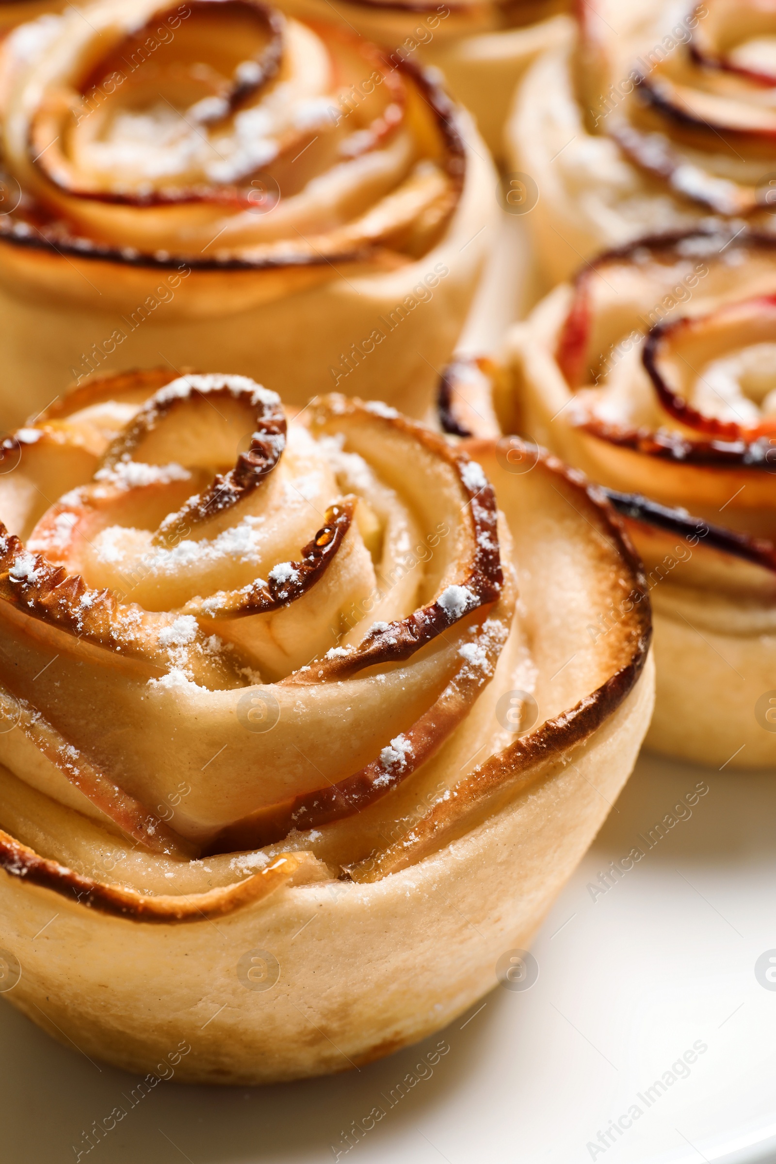 Photo of Freshly baked apple roses on light background, closeup. Beautiful dessert