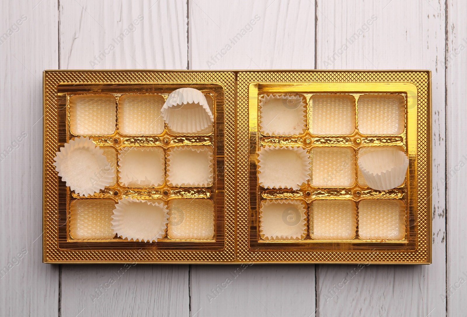 Photo of Empty box of chocolate candies on white wooden table, top view