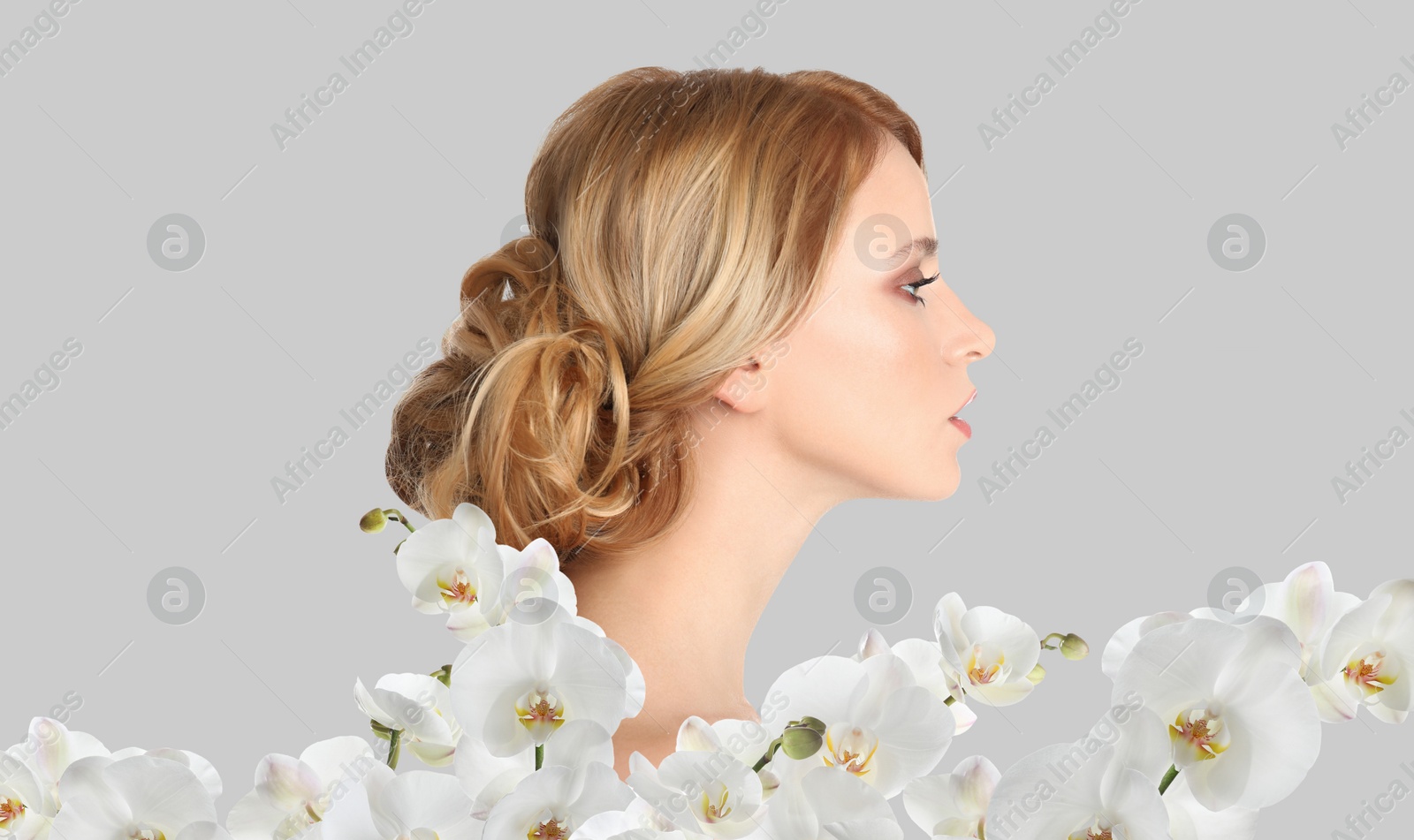 Image of Beautiful young woman and orchid flowers on light background. Spa portrait