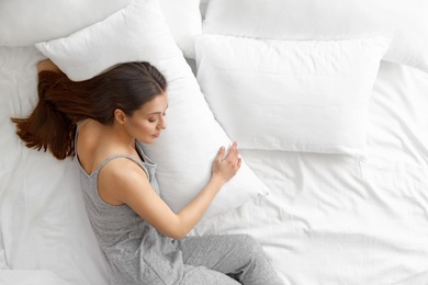 Photo of Portrait of beautiful young woman sleeping in large bed, above view