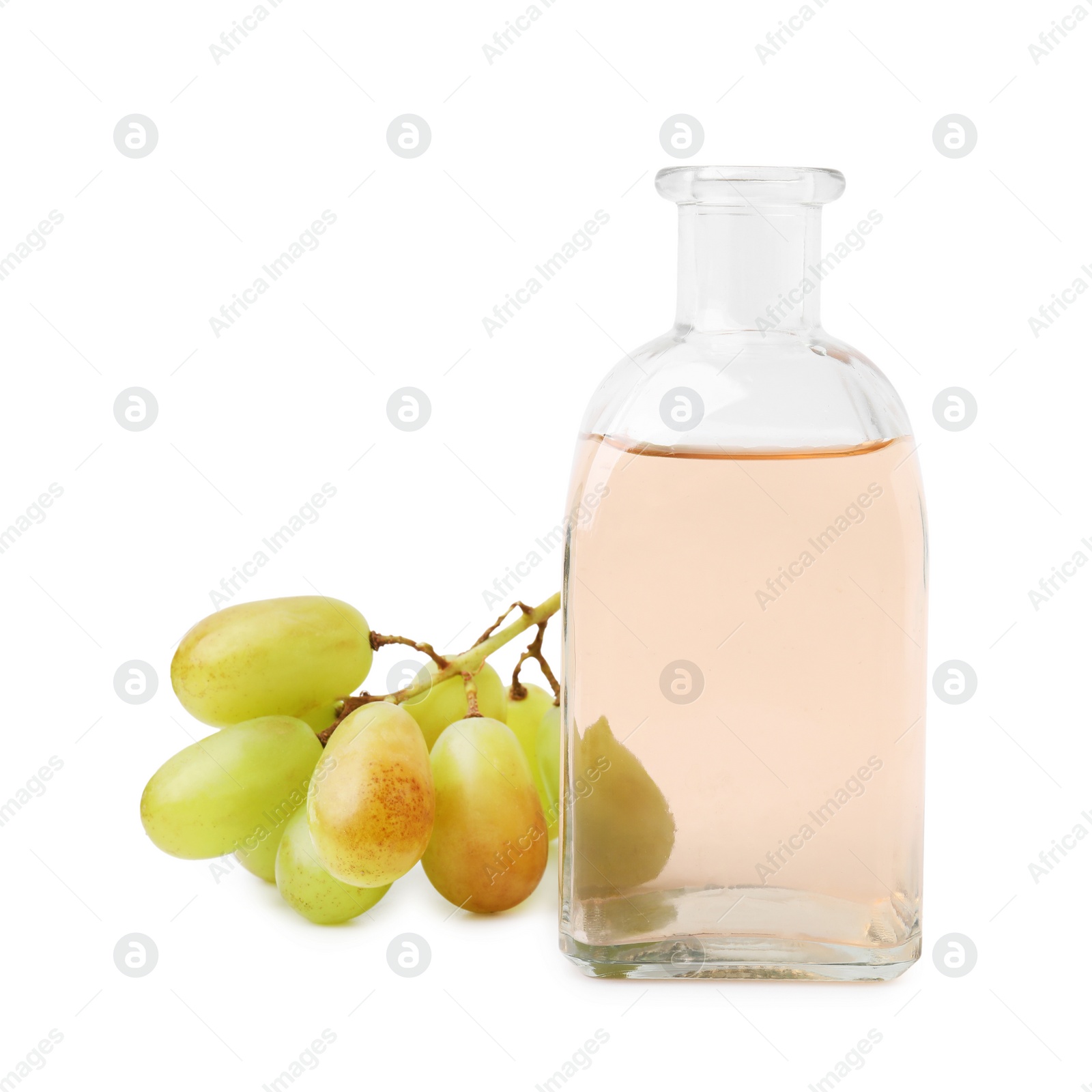 Photo of Grape vinegar in bottle and berries isolated on white