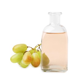 Photo of Grape vinegar in bottle and berries isolated on white