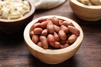 Fresh peanuts in bowl on wooden table