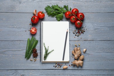 Photo of Open recipe book and fresh products on grey wooden table, flat lay. Space for text