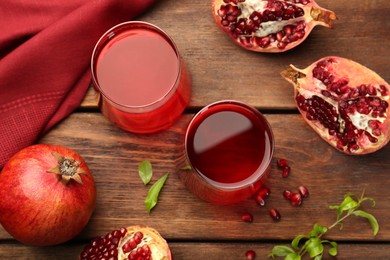 Photo of Tasty pomegranate juice in glasses and fresh fruits on wooden table, flat lay