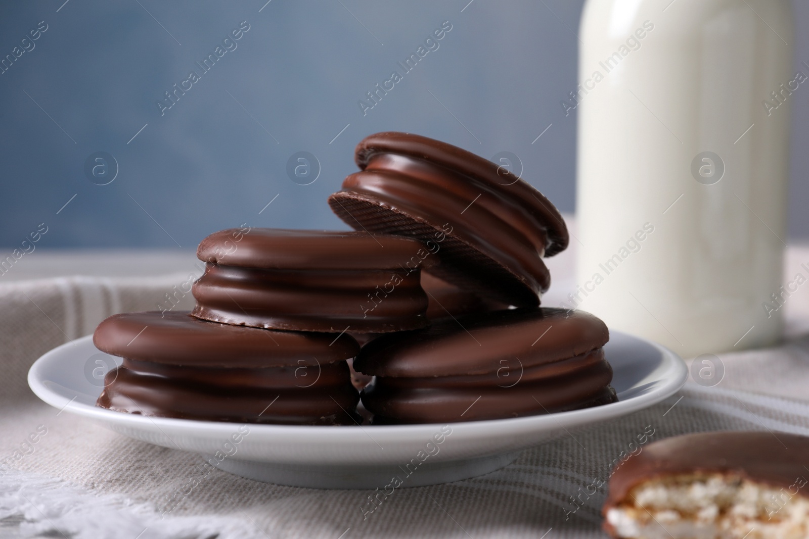 Photo of Tasty choco pies and milk on white wooden table