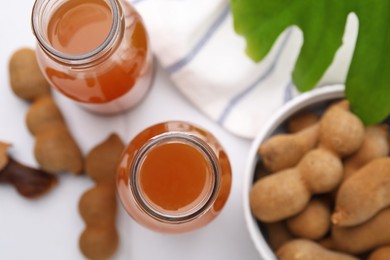 Tamarind juice and fresh fruits on white table, flat lay