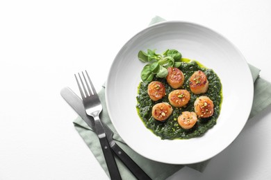 Delicious fried scallops in bowl served on white table, flat lay. Space for text