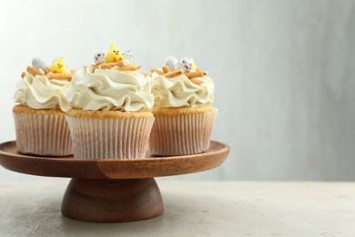 Tasty Easter cupcakes with vanilla cream on gray table, space for text