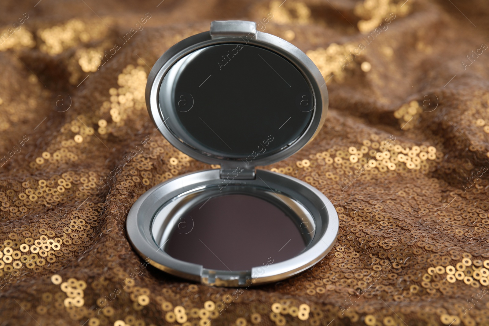 Photo of Grey cosmetic pocket mirror on gold fabric