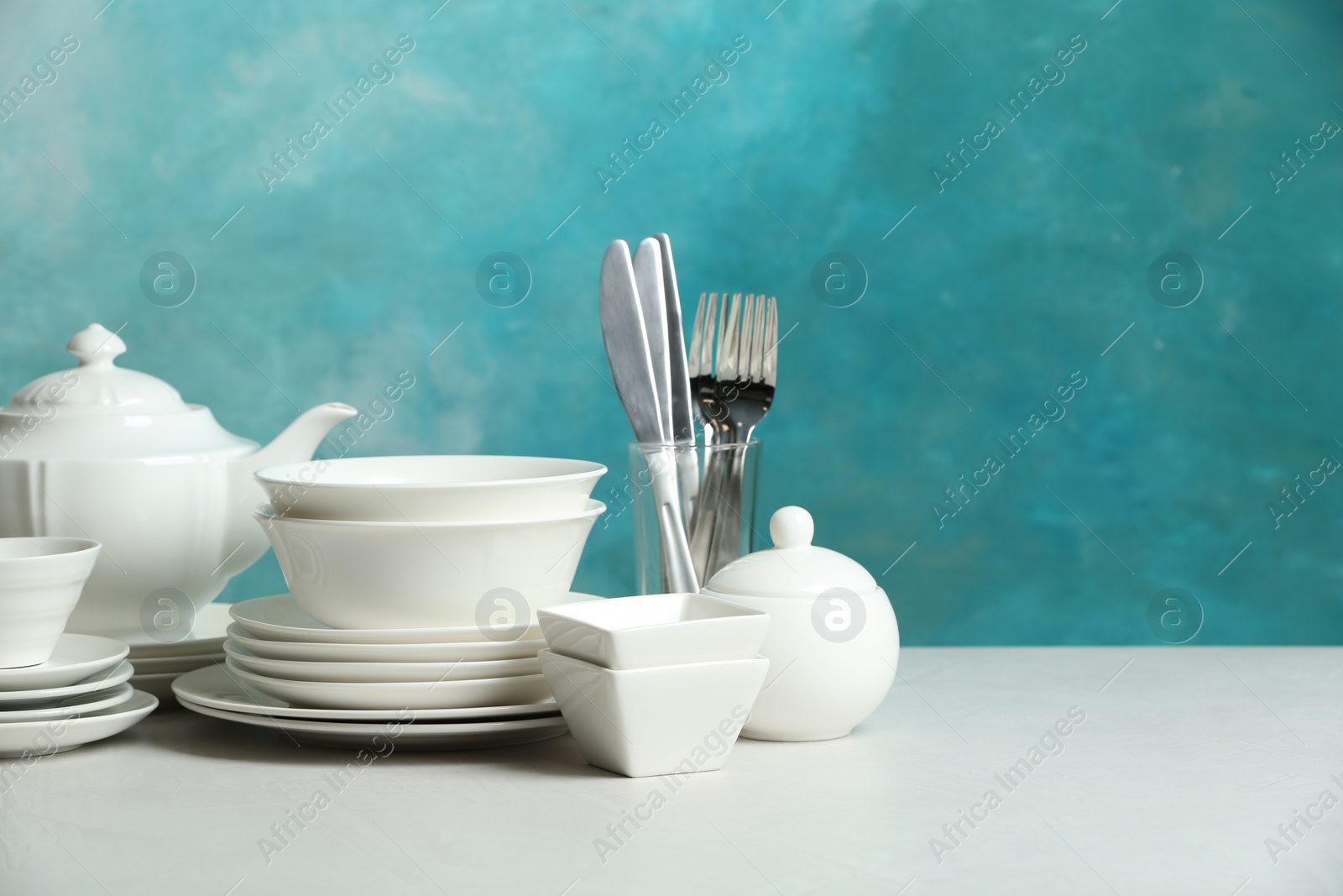 Photo of Set of clean dishes on table against blurred background. Space for text