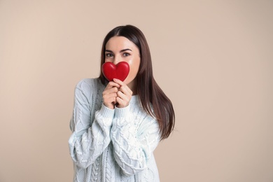 Photo of Portrait of young woman with decorative red heart on color background. Space for text