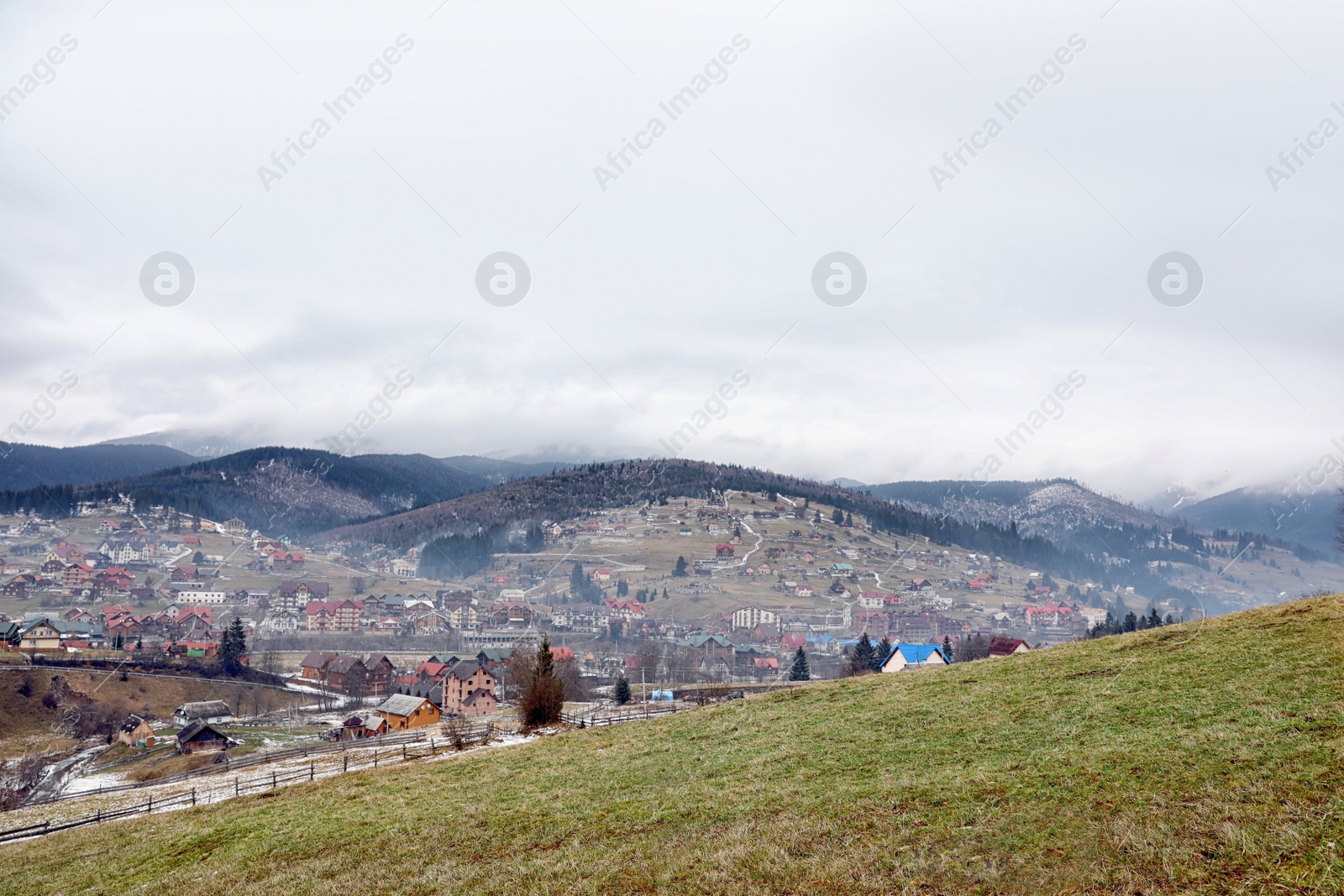 Photo of Beautiful winter landscape with buildings and forest on hills