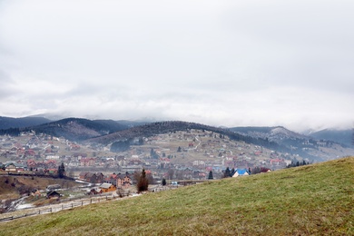 Beautiful winter landscape with buildings and forest on hills