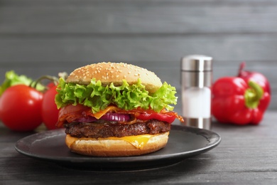 Photo of Plate with tasty burger on wooden table