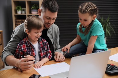 Happy man combining parenting and work at home