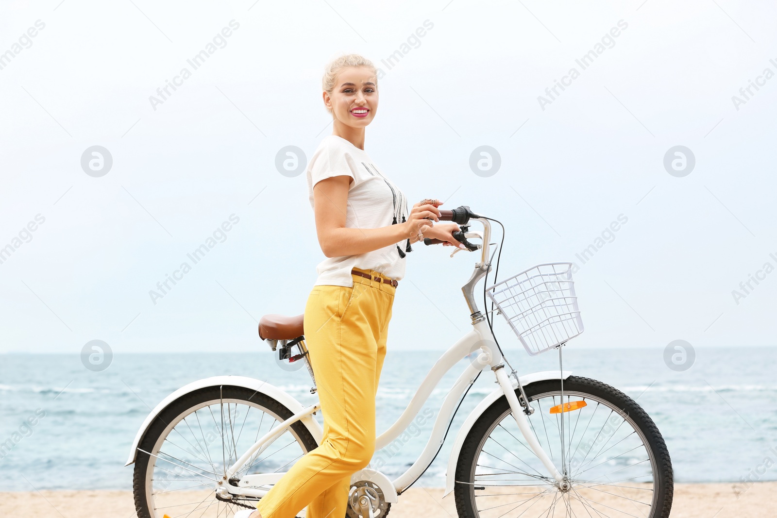 Photo of Beautiful woman in casual outfit with bicycle on sea coast