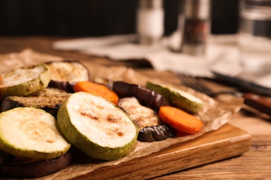 Photo of Delicious grilled vegetables served on wooden table, closeup