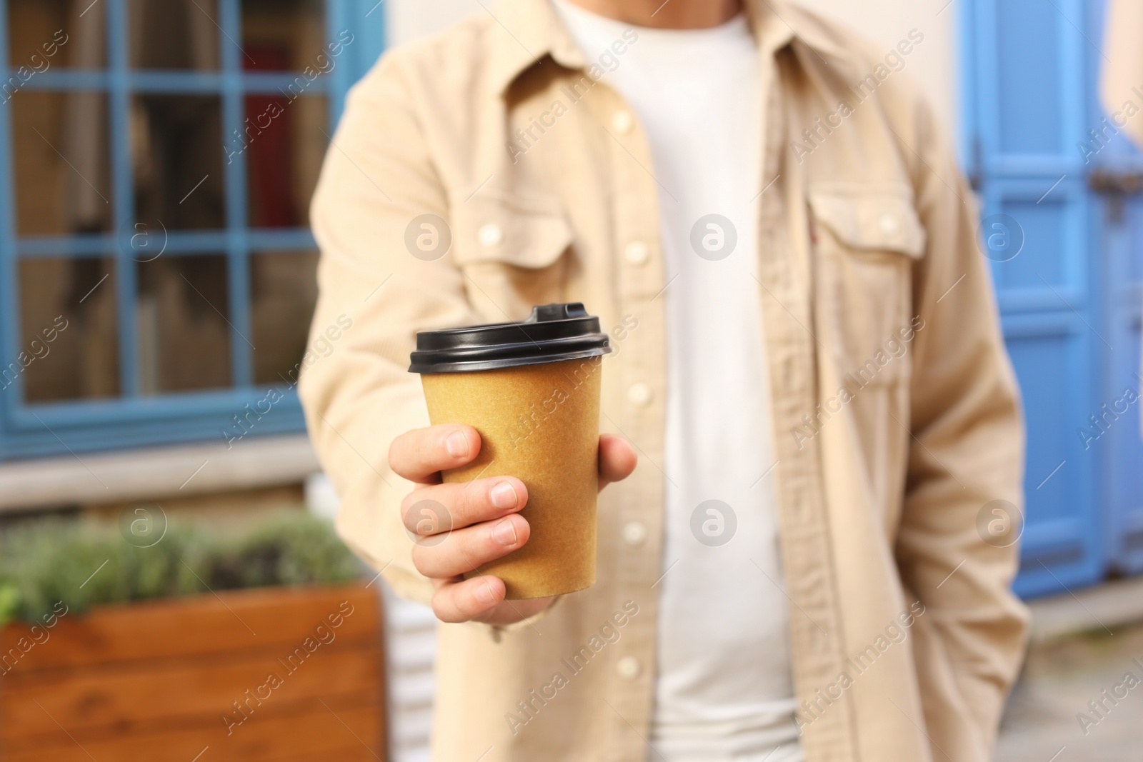 Photo of Coffee to go. Man with paper cup of drink outdoors, selective focus