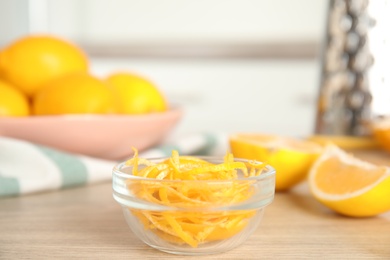 Photo of Grated lemon zest and fresh fruits on wooden table