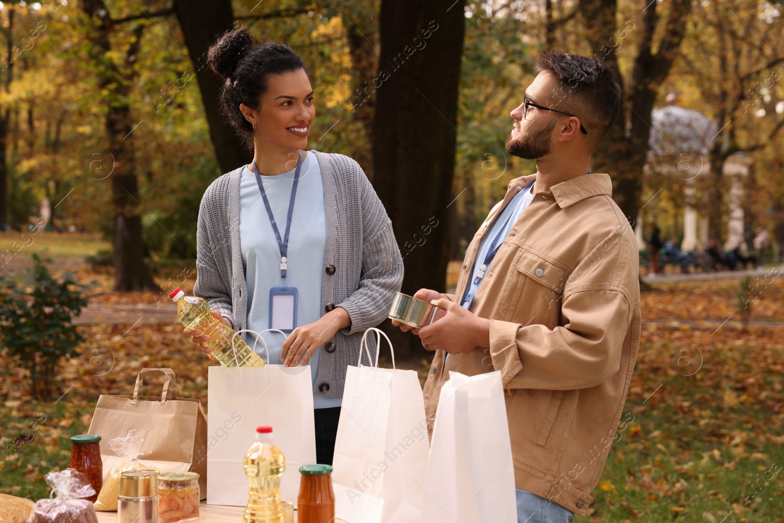 Photo of Volunteers packing food products at table in park