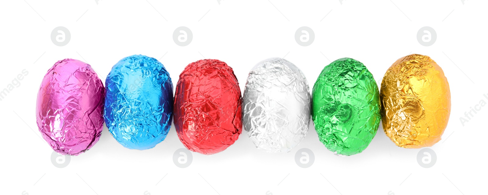 Photo of Many chocolate eggs wrapped in bright foil on white background, top view