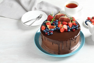 Photo of Fresh delicious homemade chocolate cake with berries on light table