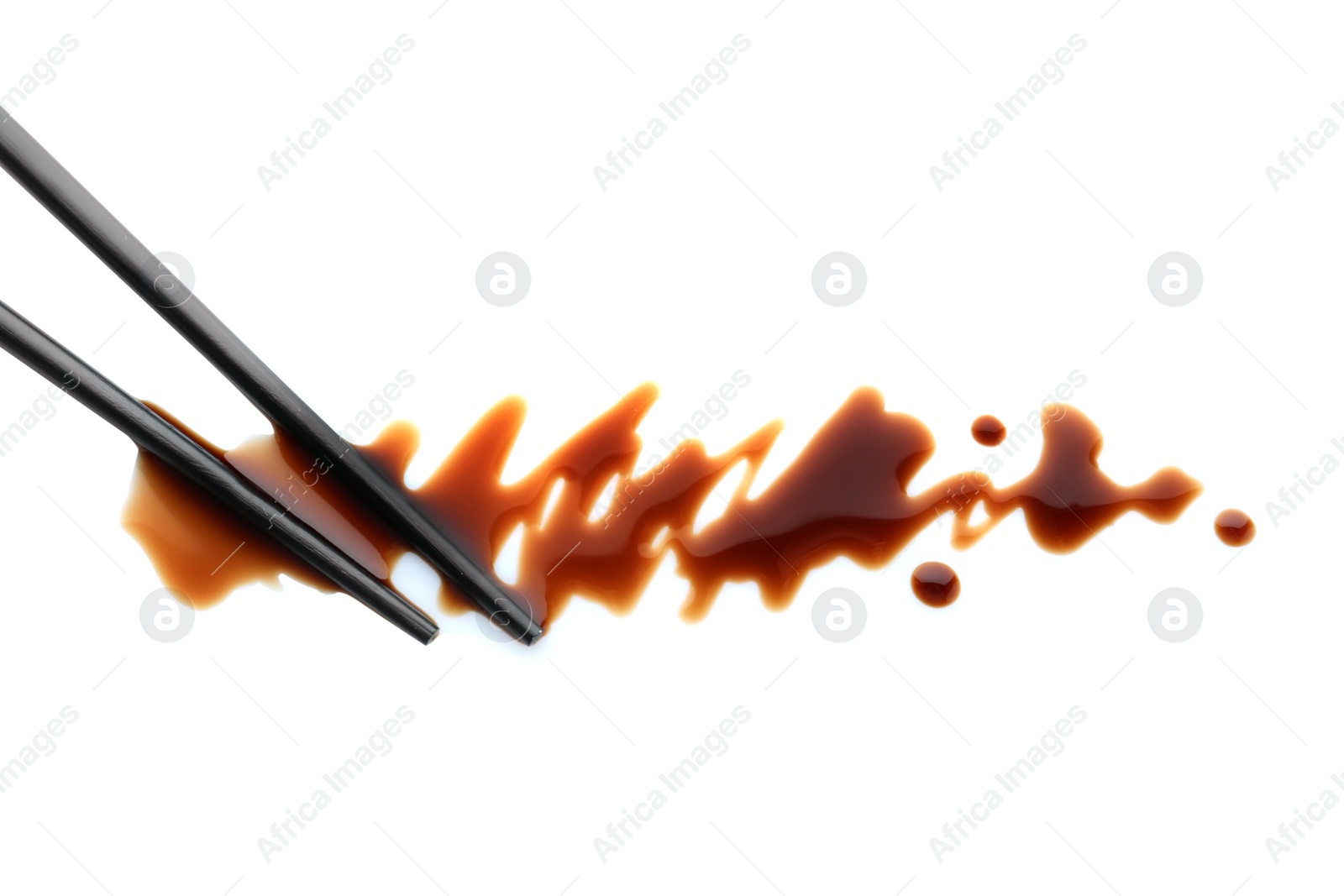 Photo of Delicious soy sauce and chopsticks isolated on white, top view