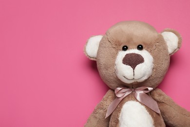 Photo of Cute teddy bear on pink background, top view. Space for text