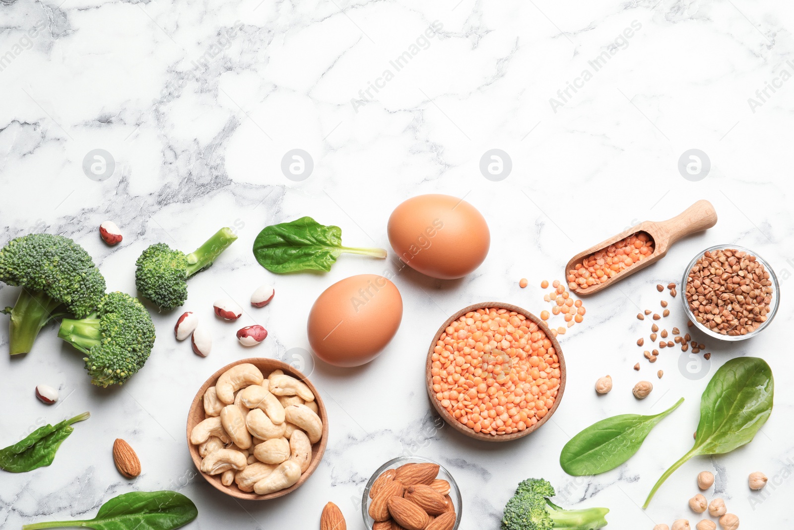 Photo of Set of natural food high in protein and space for text on marble background, top view