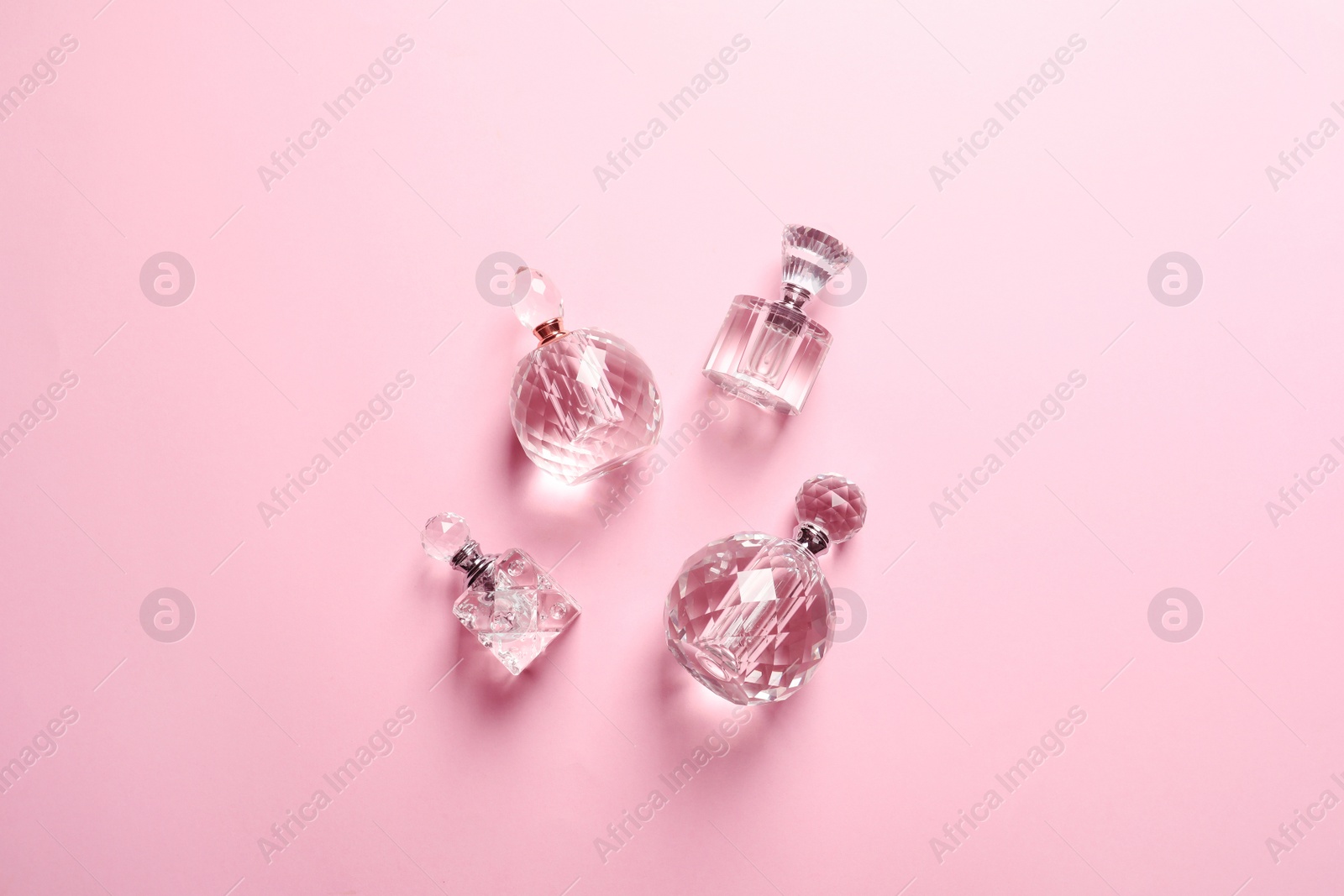 Photo of Flat lay composition with bottles of perfume on pink background