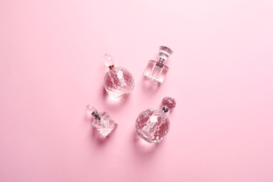 Flat lay composition with bottles of perfume on pink background
