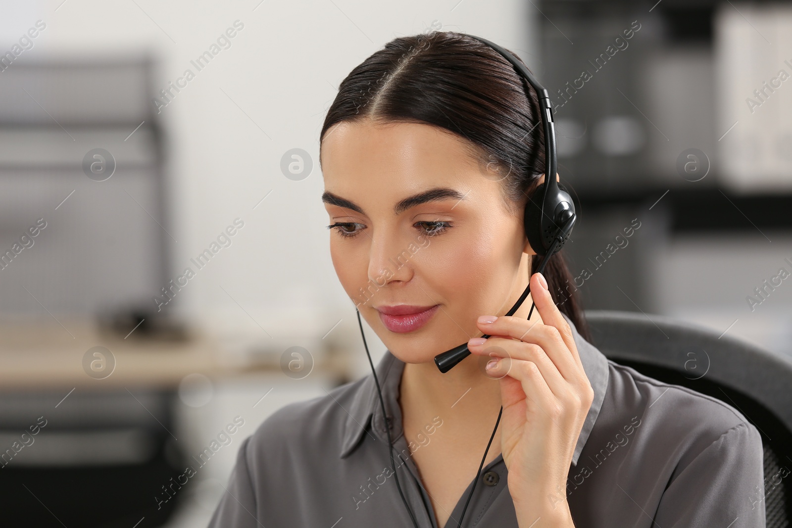 Photo of Hotline operator with headset working in office