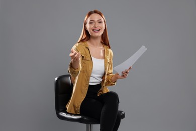 Photo of Casting call. Young woman with script performing on grey background