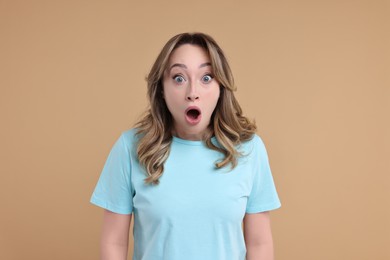 Portrait of surprised woman on beige background