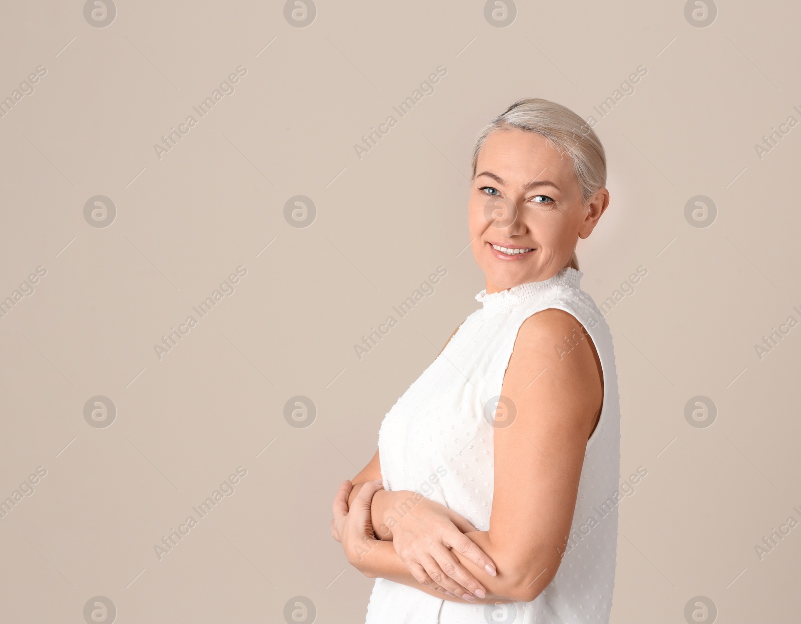 Photo of Portrait of beautiful mature woman on beige background. Space for text