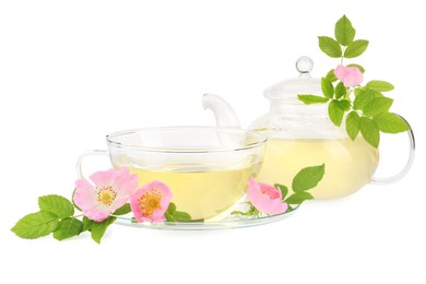 Photo of Aromatic herbal tea in glass cup, teapot, flowers and green leaves isolated on white