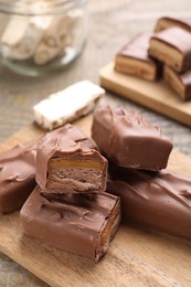 Photo of Tasty chocolate bars with nougat on wooden table, closeup