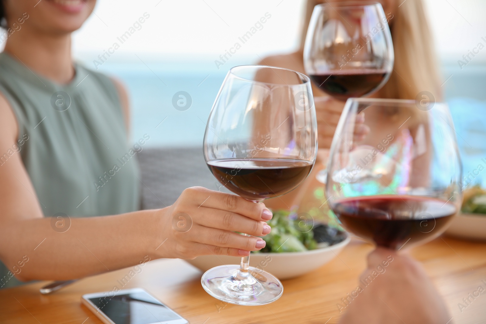 Photo of Group of friends with glasses of wine at table