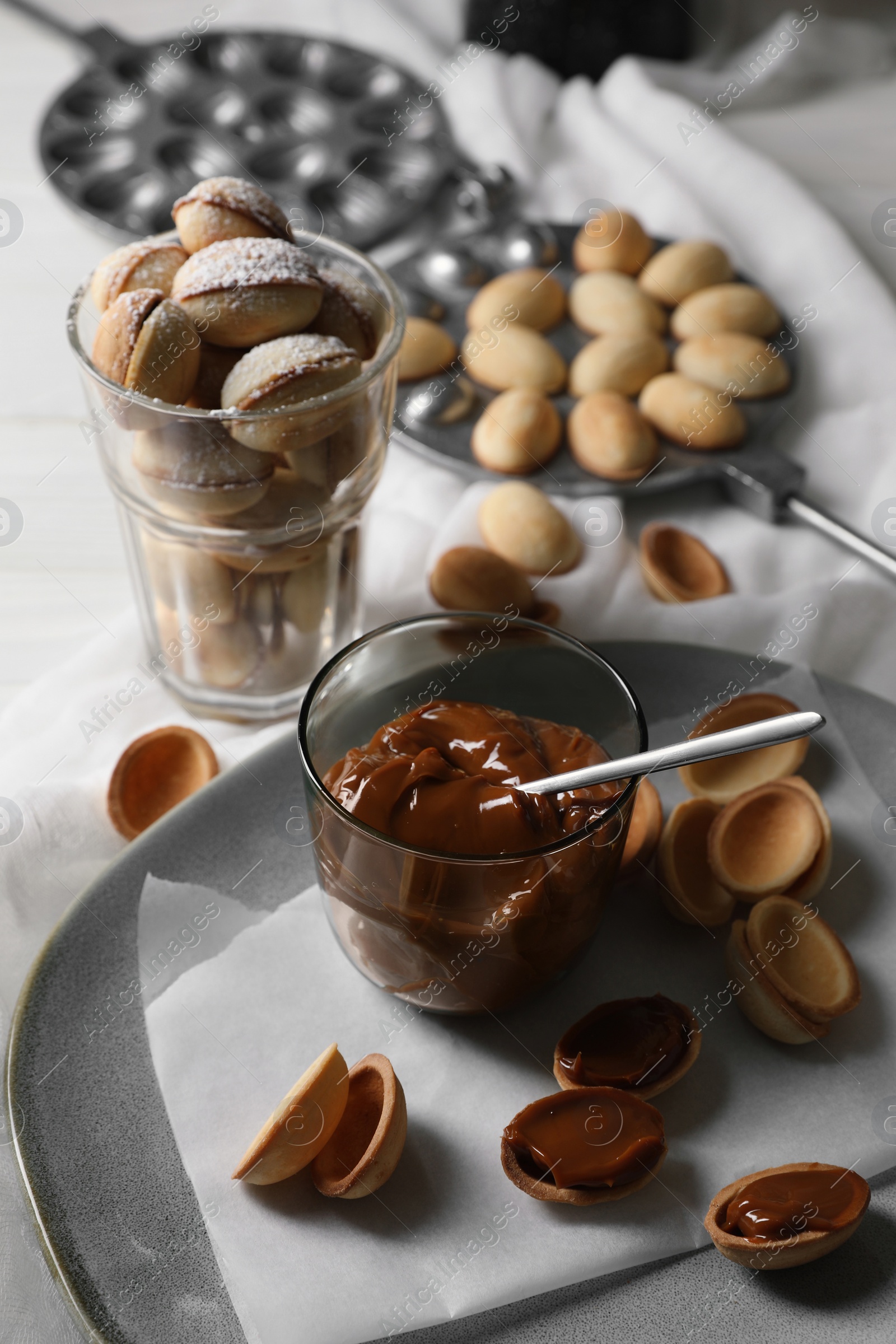 Photo of Delicious walnut shaped cookies with condensed milk on table, above view