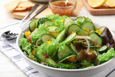 Delicious cucumber salad served on white wooden table, closeup