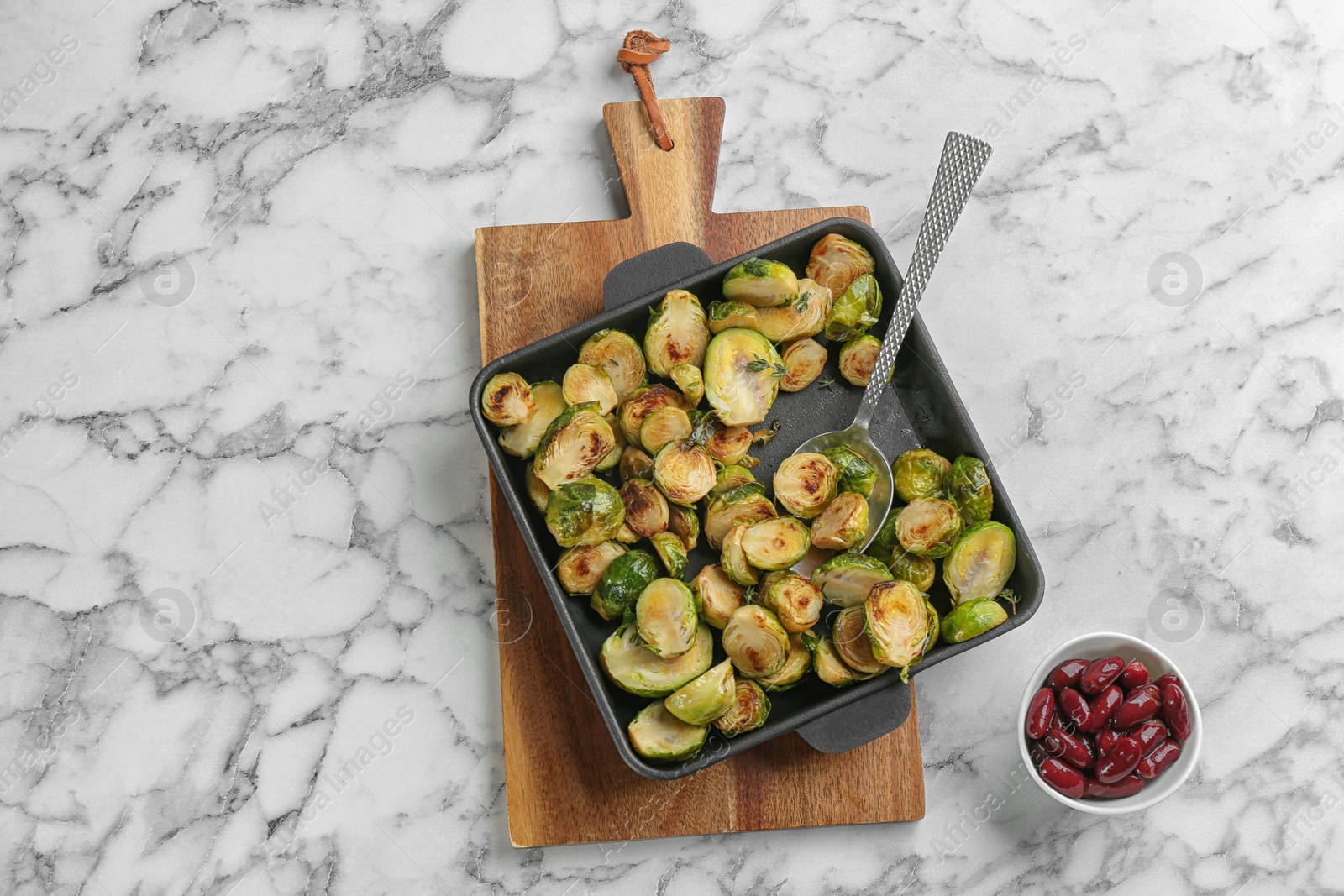 Photo of Delicious roasted brussels sprouts on white marble table, flat lay