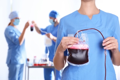 Photo of Doctor holding blood pack for transfusion at hospital, closeup. Donation day