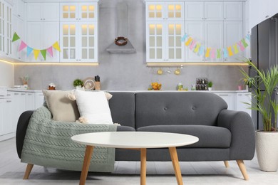 Gray sofa, white wooden table and Easter decor in kitchen