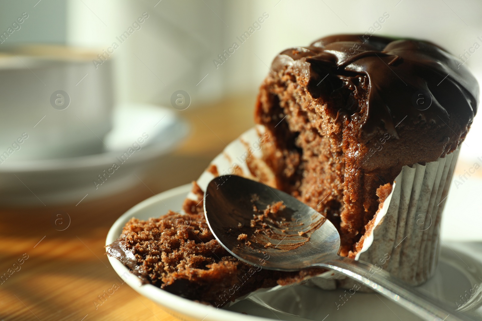 Photo of Cup of fresh aromatic coffee and cupcake at table in cafe