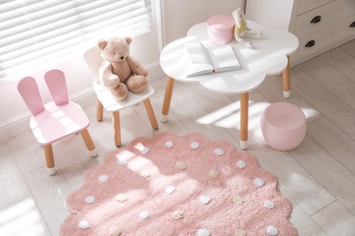 Round pink rug on floor in children's room, above view