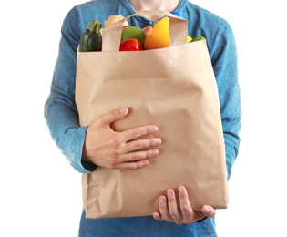 Photo of Man holding paper bag with different groceries on white background, closeup view