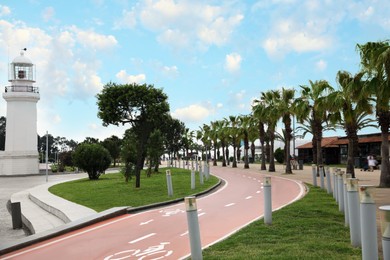 Photo of Street of resort town with lighthouse, palms and two way bicycle lane