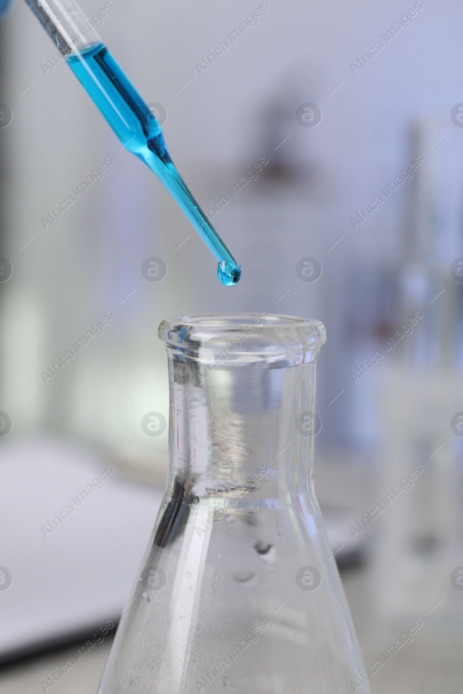 Photo of Laboratory analysis. Dripping liquid into flask on table, closeup